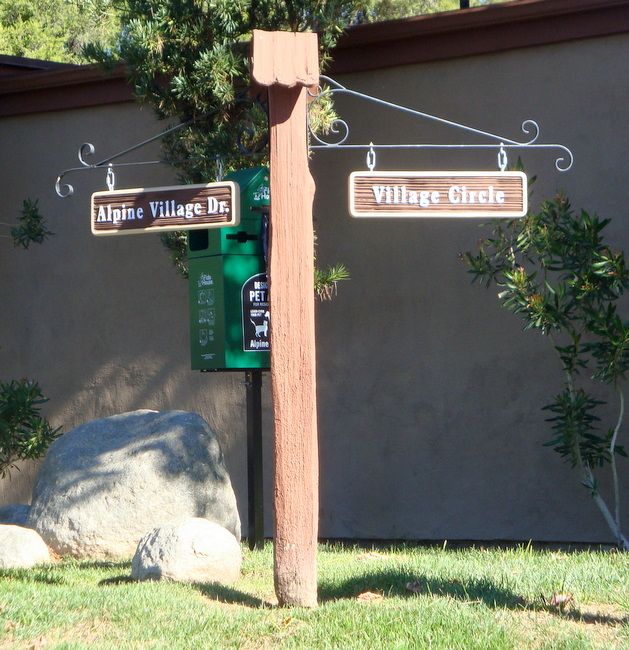 KA20666 - Carved Wood Grain Directional Street Signtivs with Wrought Iron Scroll Brackets Mounted on Cedar Wood Post