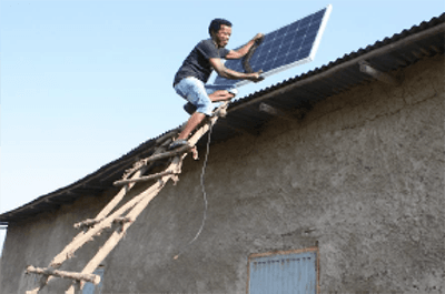 Man on roof installing solar panel.