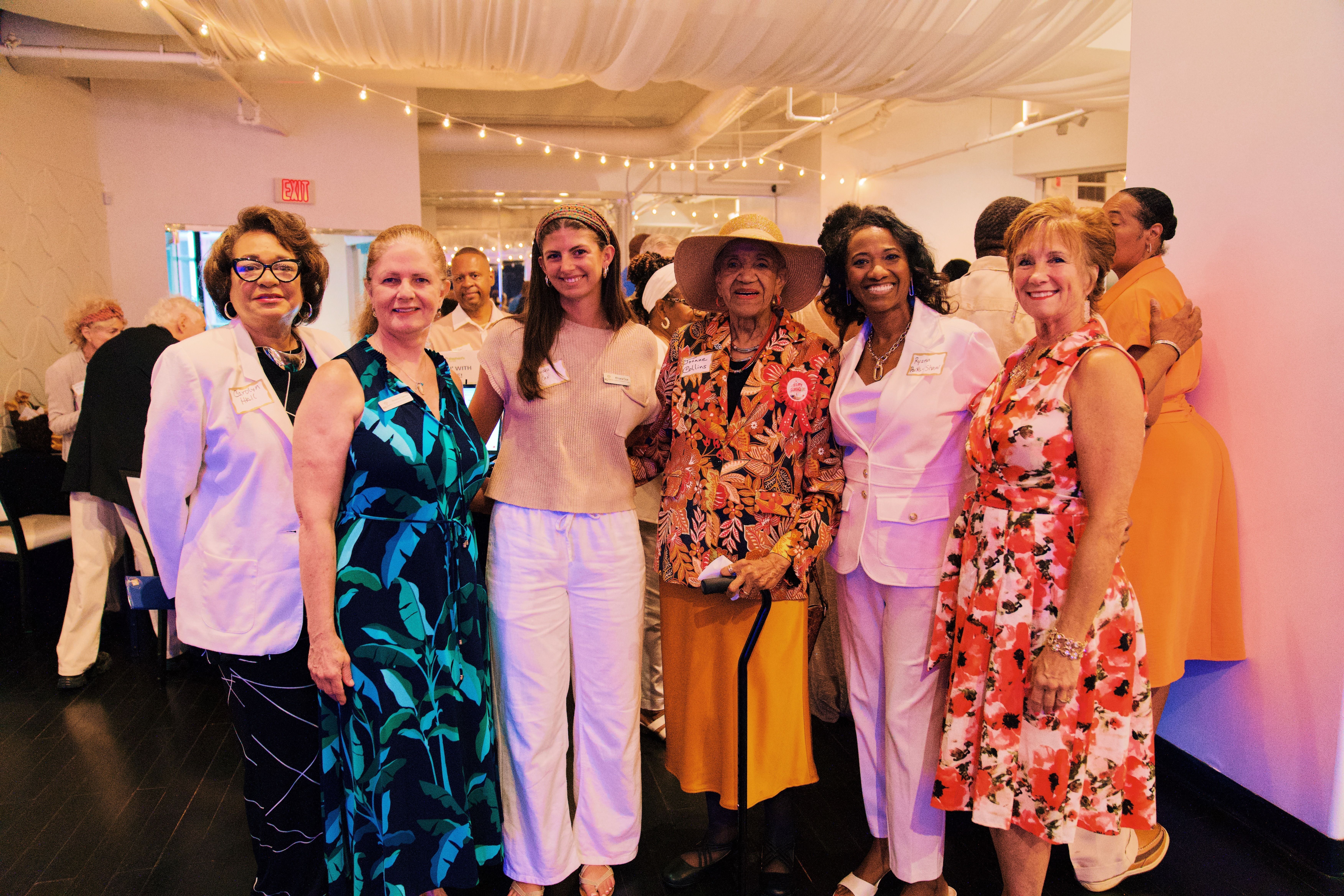 A groups of women with Joan Collins, looking at the camera 