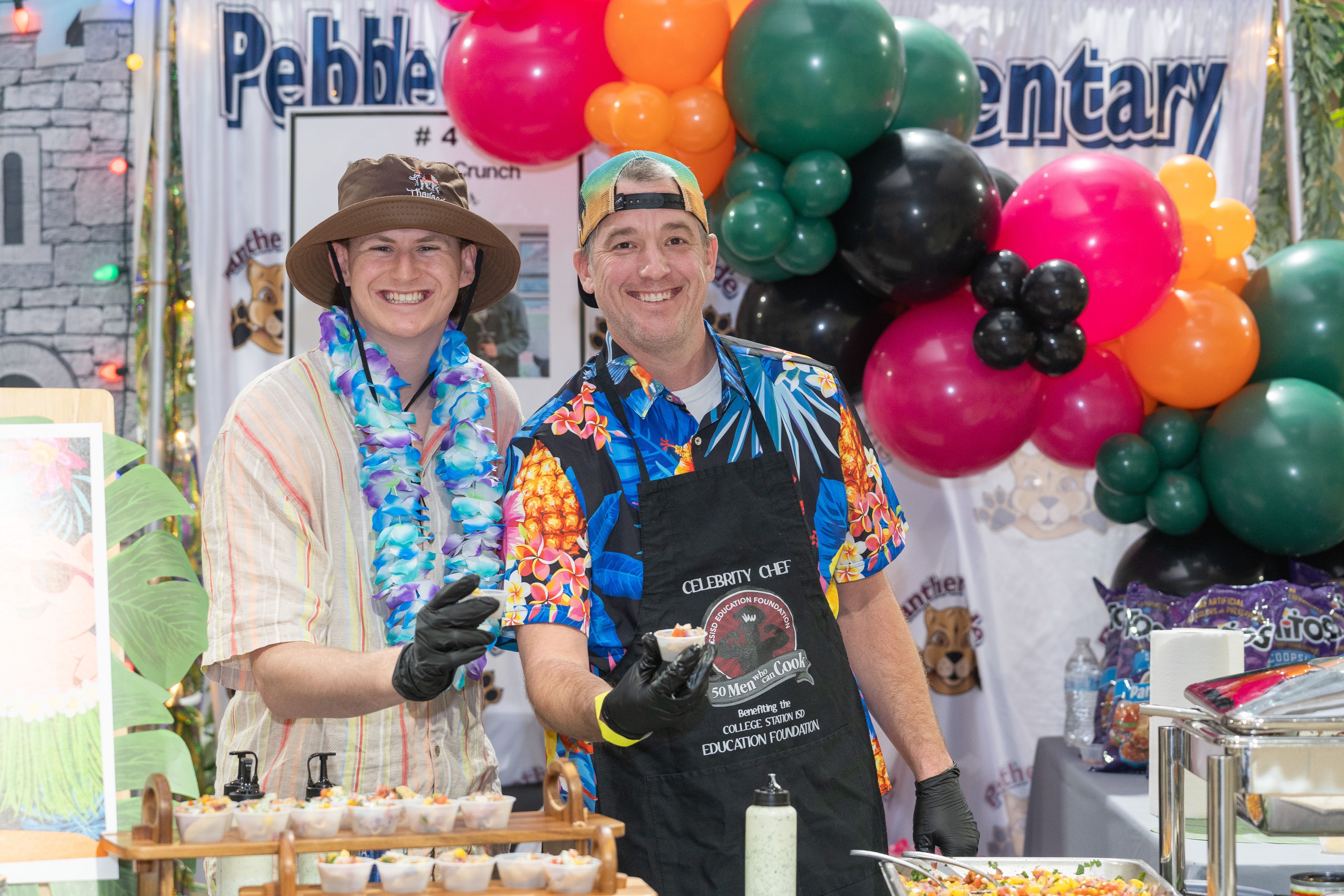 Three men serving food from a booth