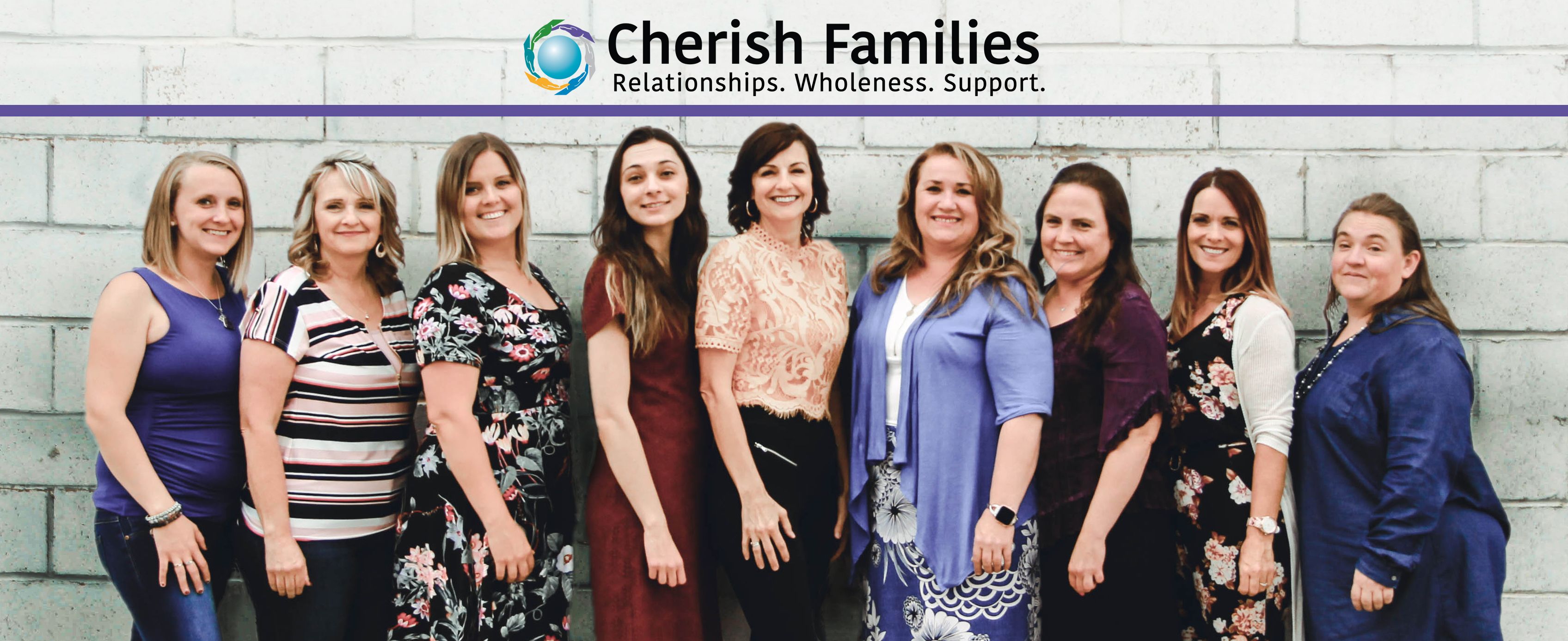 Cherish Families staff posing in front of the beautiful red mountains of Southern Utah