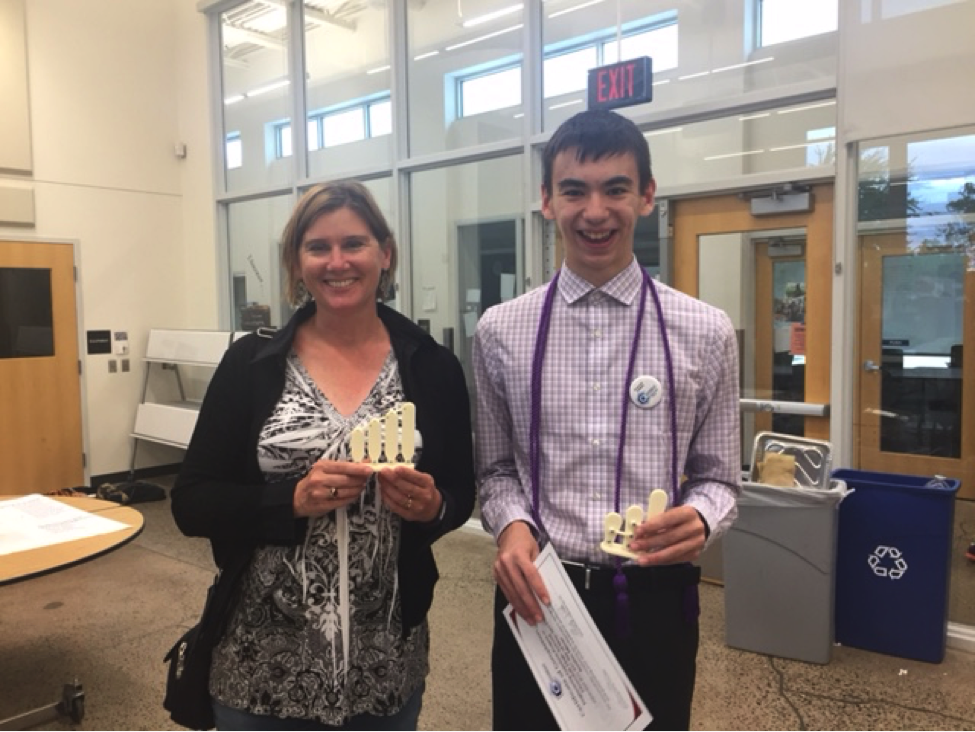 en Phillips and Austin holding 3D models of hair bundles and smiling.