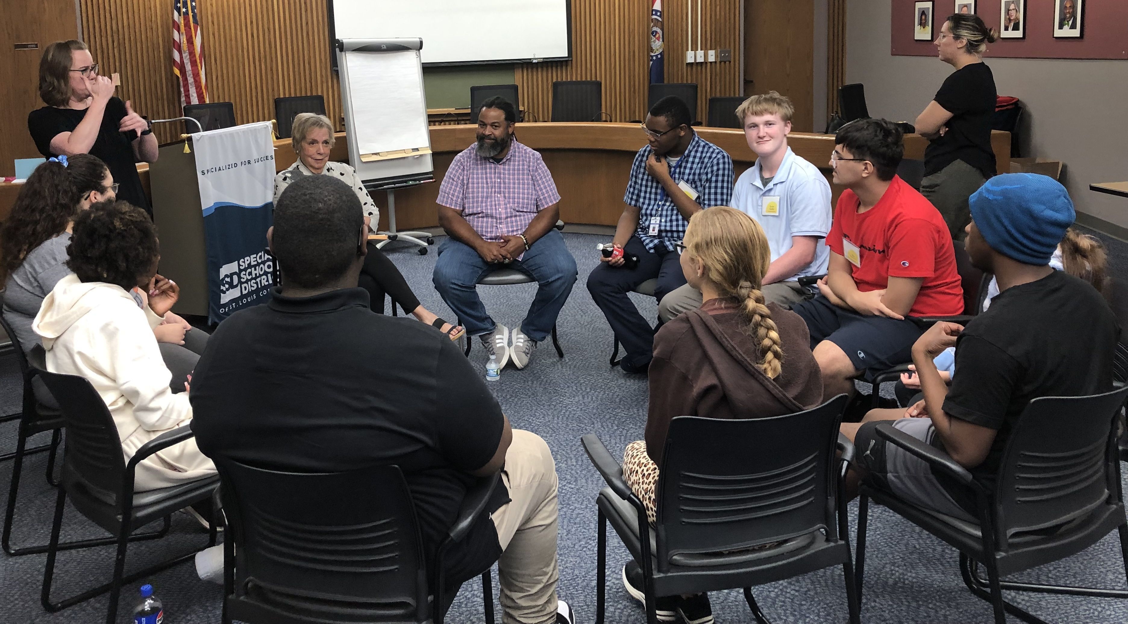 students sitting in a board room in a circle