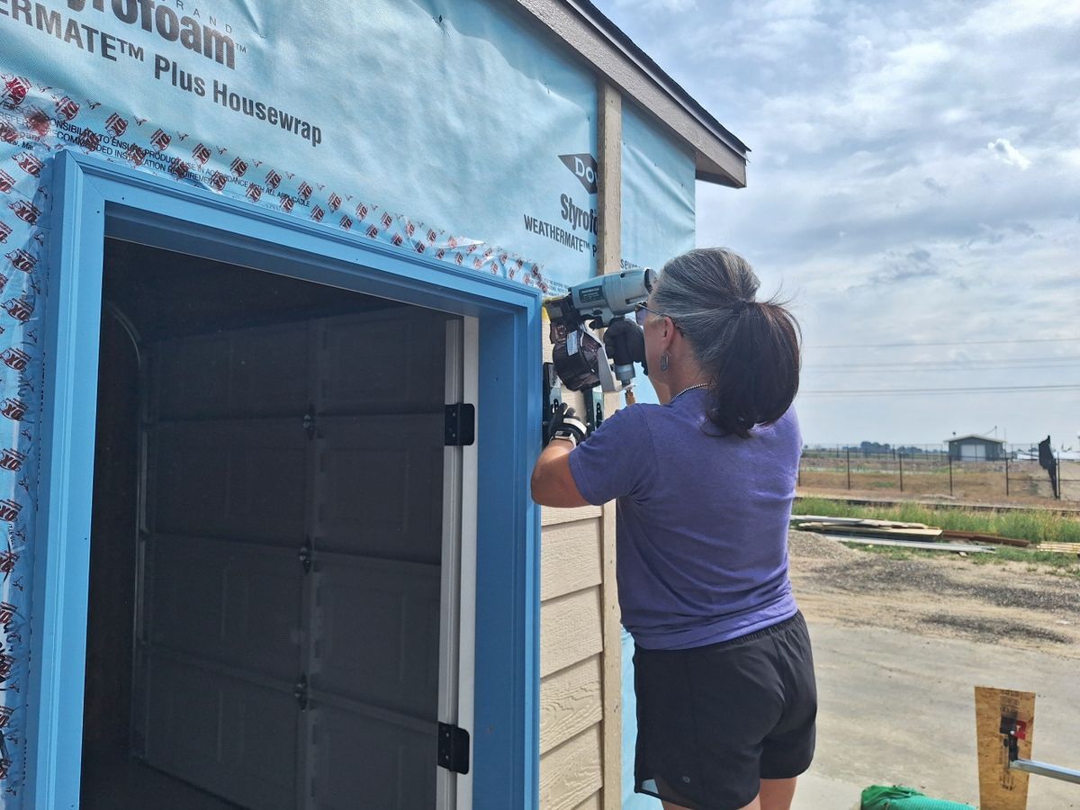 Women's Build: Volunteer using staple gun in the garage