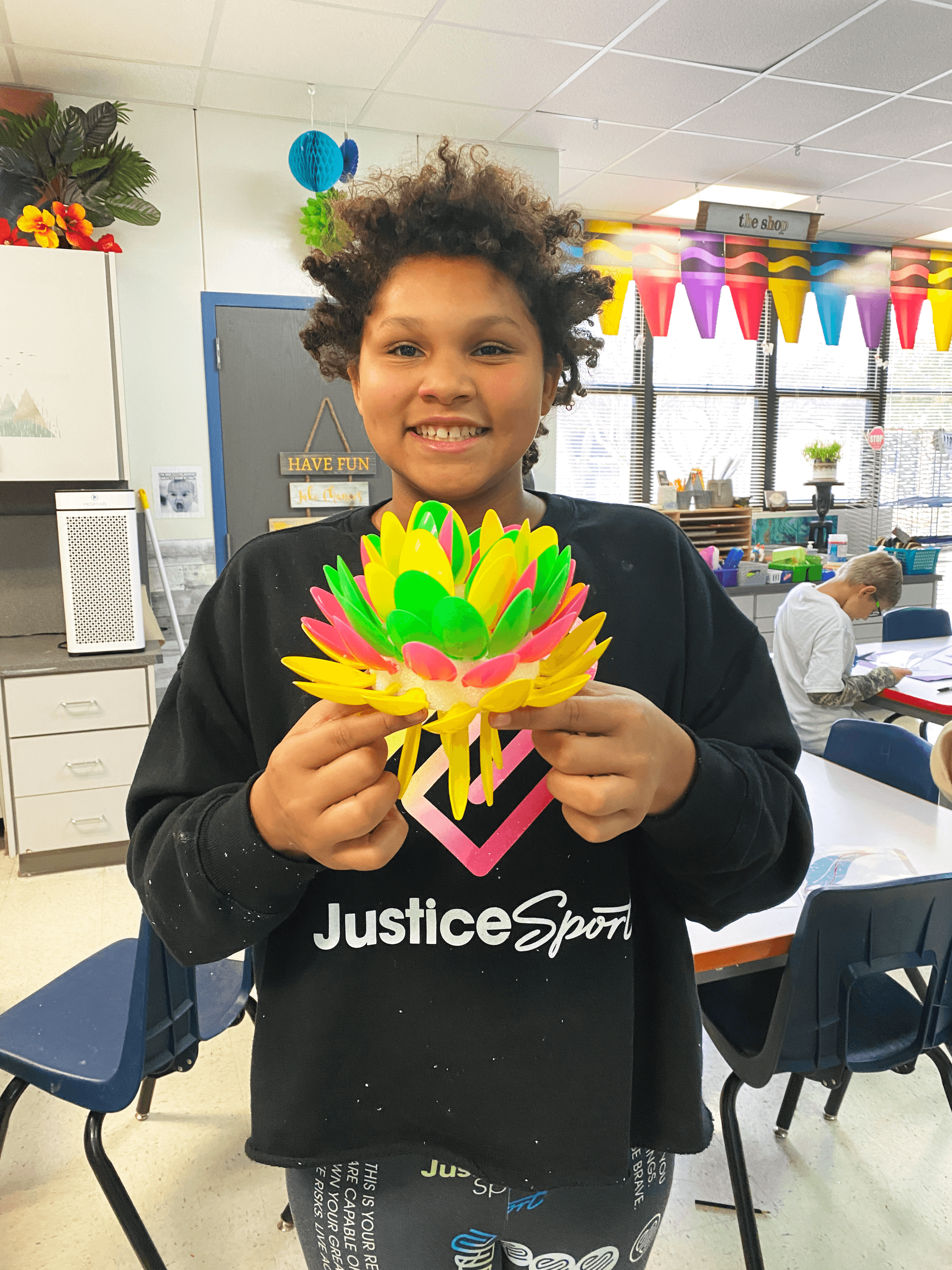 Picture of Ethridge student holding her Chihuly art project and smiling