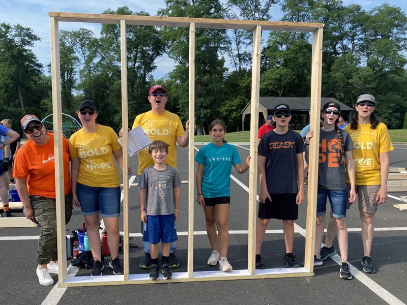 Be Hope church members stand with a house frame that they helped to build for Dayton Habitat.