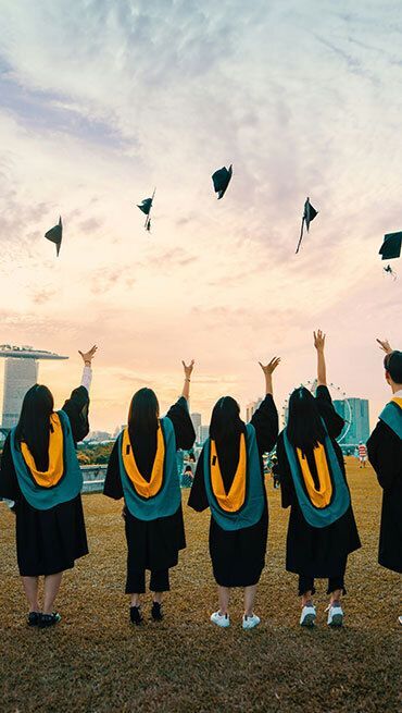 Students throwing their graduation caps in the air.