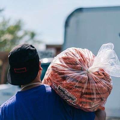 Food bank partner carrying a large bag of carrots