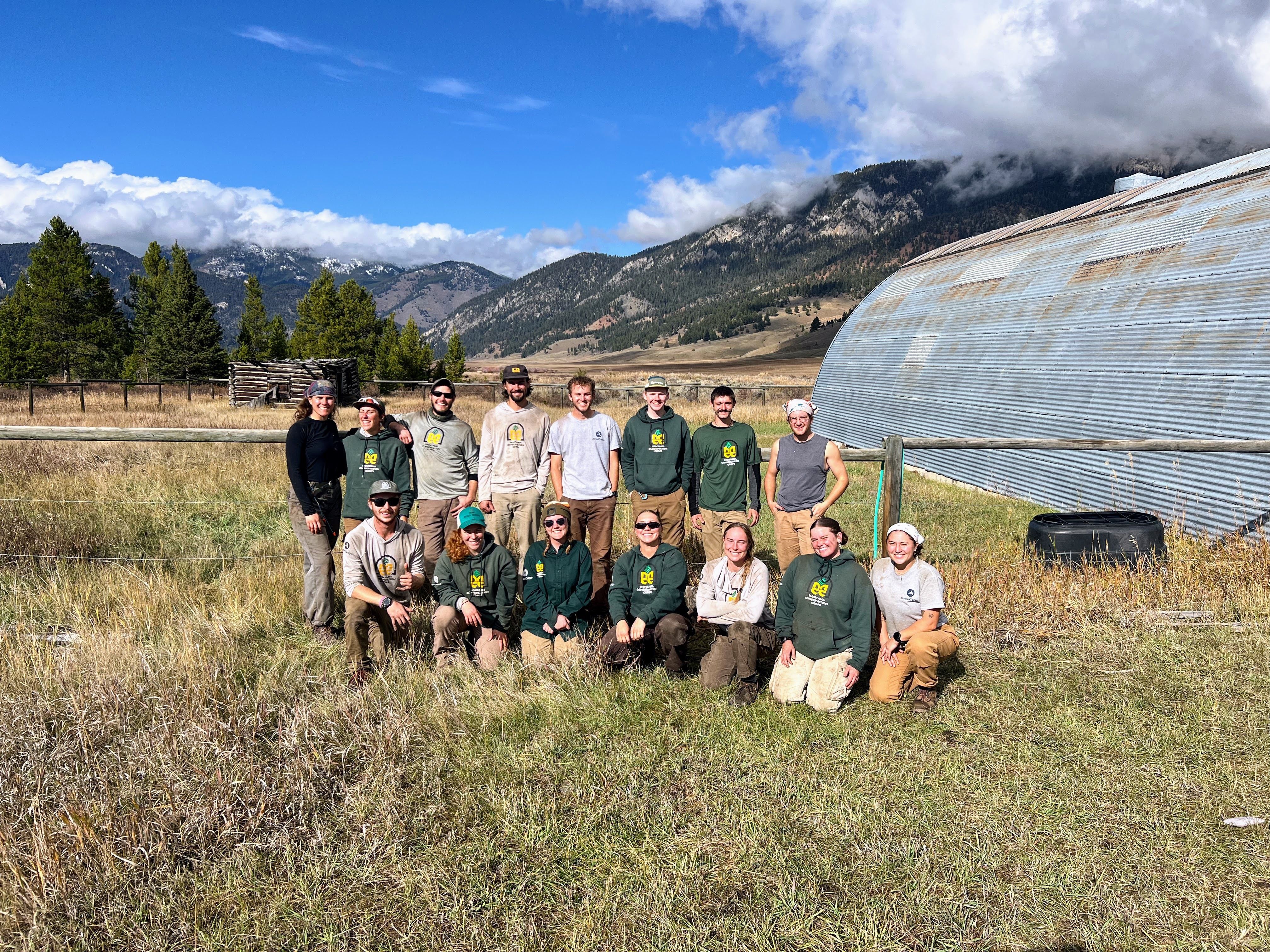 Three MCC crews stand in front of a metal bunk house.