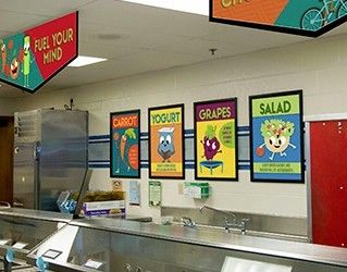 School serving line showing 4 food posters of food characters, nutrition education, school signs