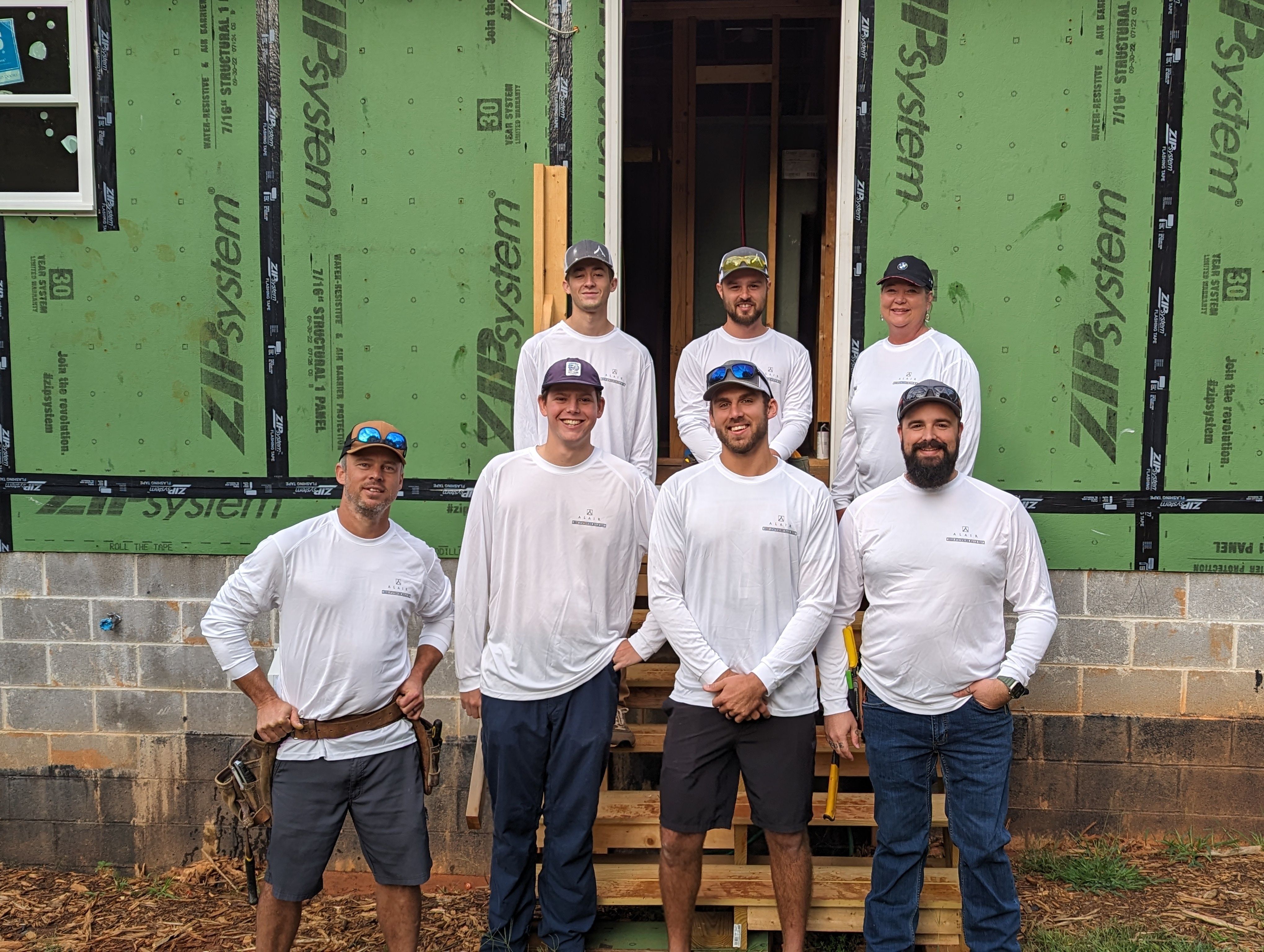 A group of 7 dedicated volunteers from Alair Homes working together on a Habitat for Humanity project.