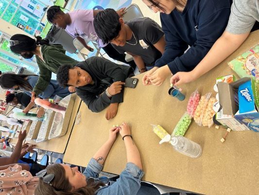 Ms. Nelson interacts with children at Operation Xcel providing hands-on learning in Science, Technology, Engineering, Arts, and Mathematics (STEAM). 