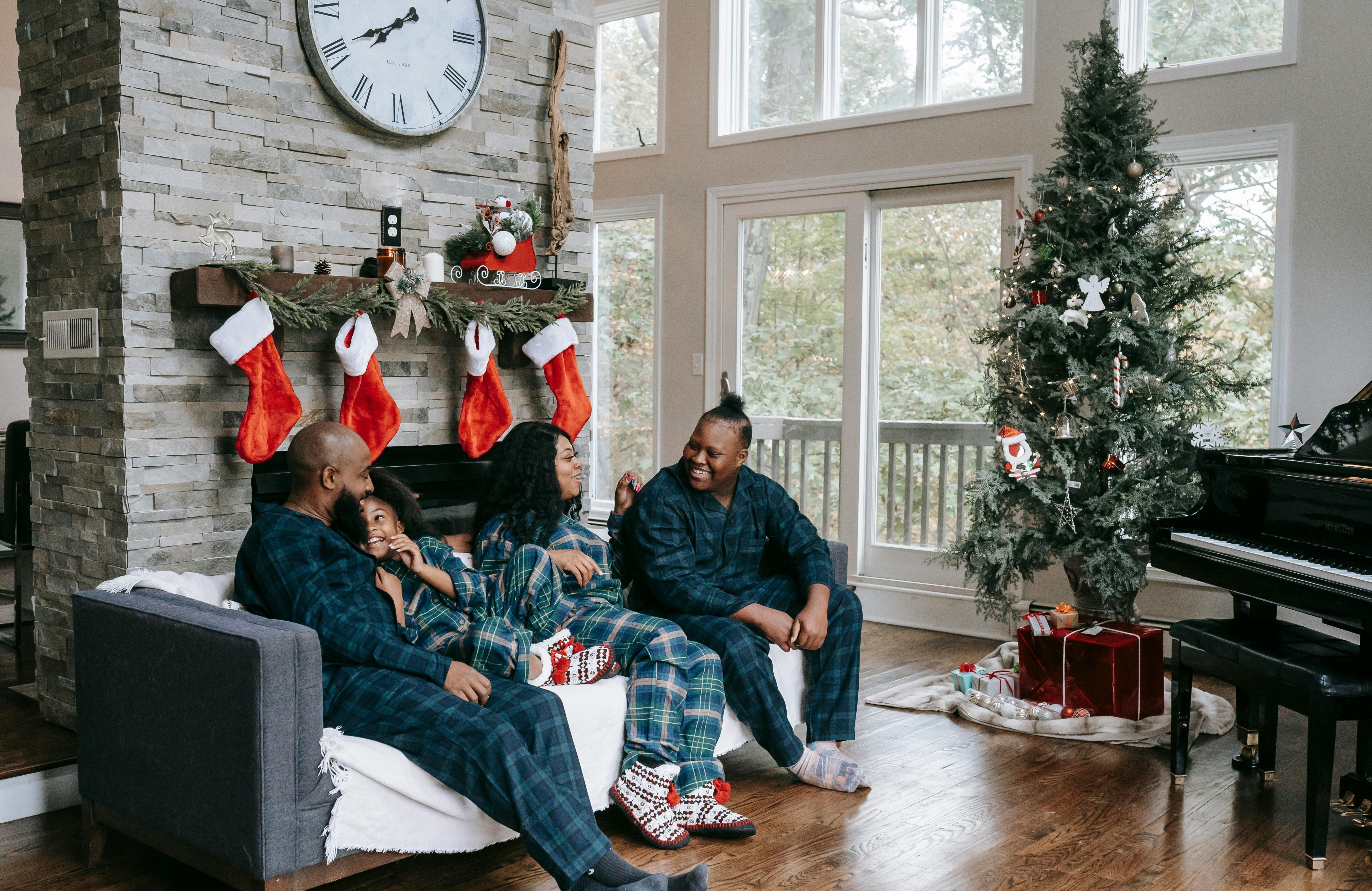 Family sitting on the couch surrounded by holiday decorations.