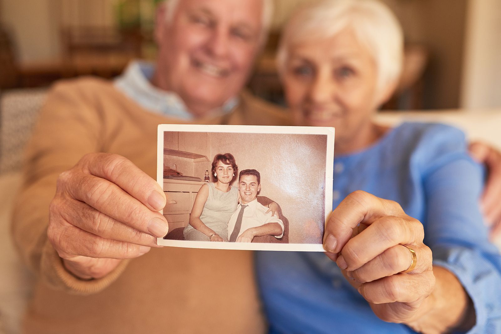 Senior couple hold a photo from their early years together