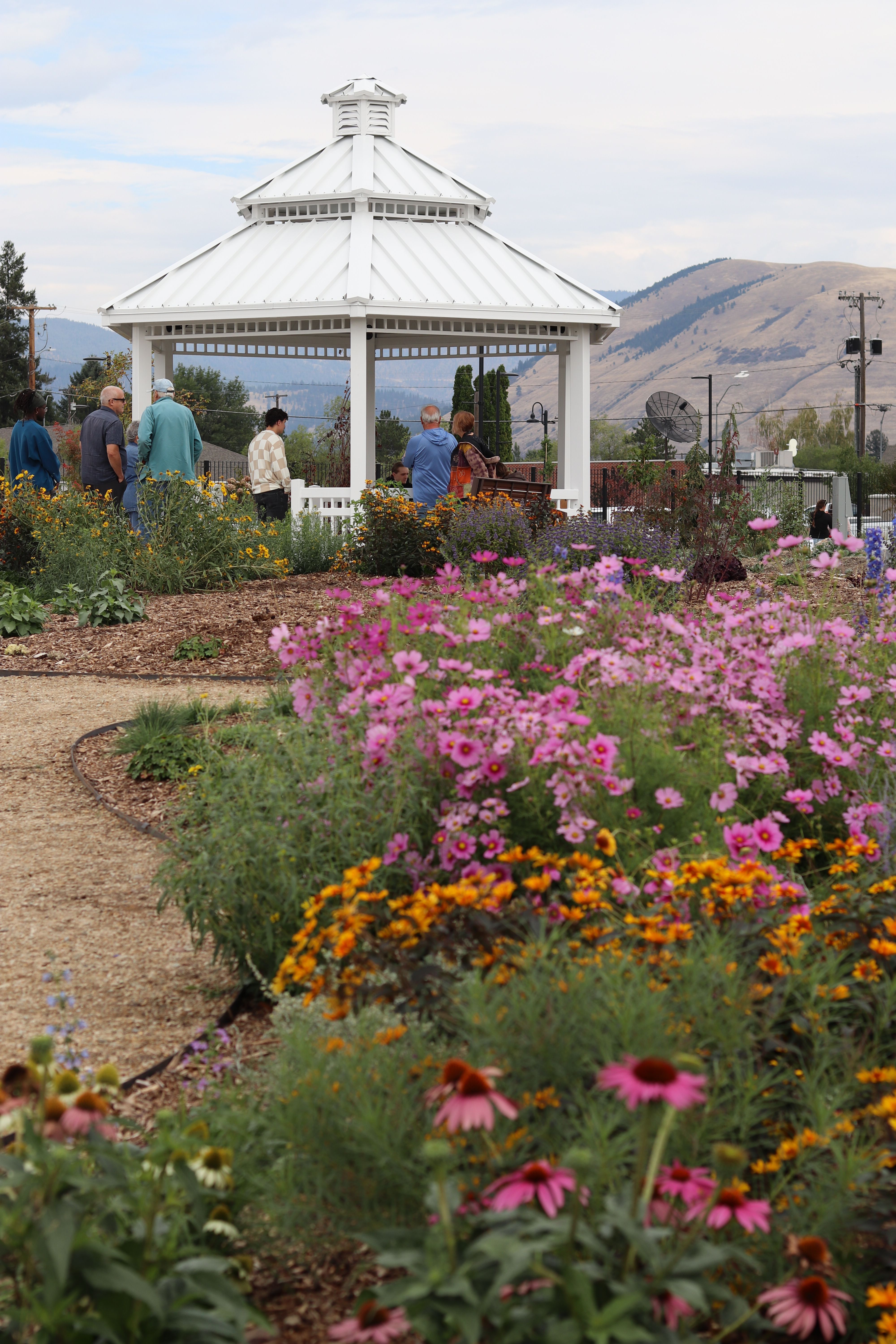 Pink and orange blooms along a pathway leading to the garden gazebo