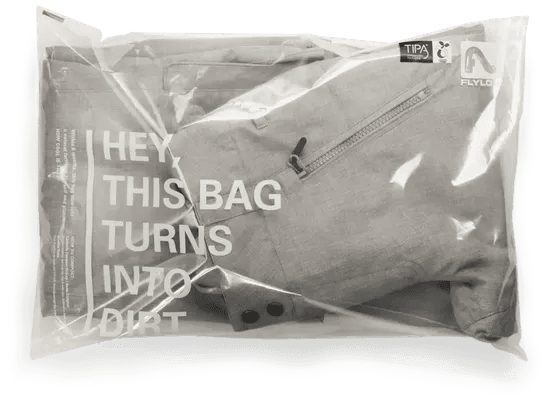 Gray jacket in a clear compostable mailer bag reading 'Hey, this bag turns into dirt,' a standout example of eco packaging design trends.