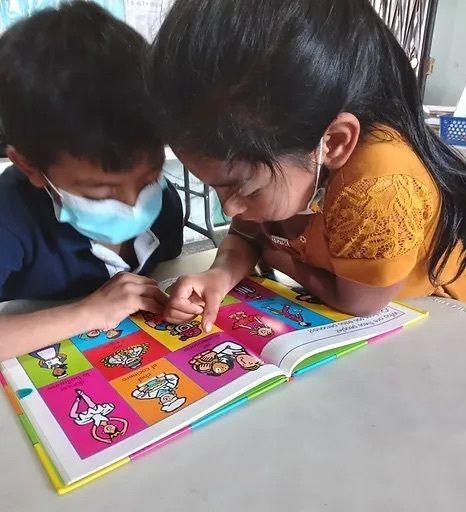 Two young children looking at a picture book.