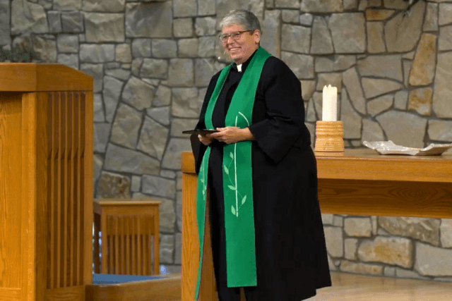 Rev Wright in black robe with green stole