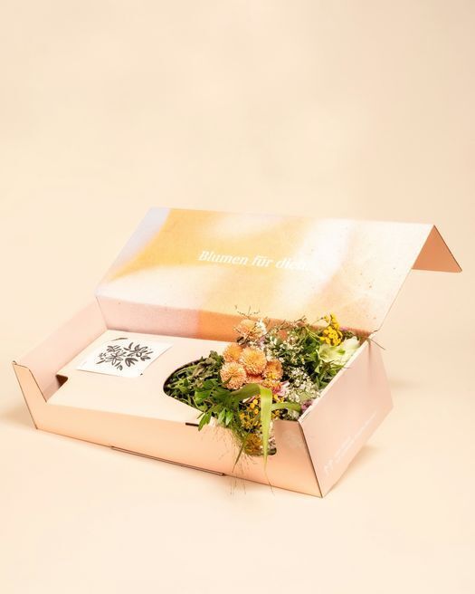 Open pastel gradient flower box labeled revealing a fresh bouquet, a creative packaging design idea for floral subscription brands.
