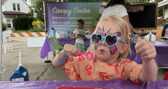 Picture of a child with blonde hair enjoying the kids fest at atwood fest