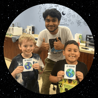 Jabari with two students smiling and giving thumbs up during summer camp