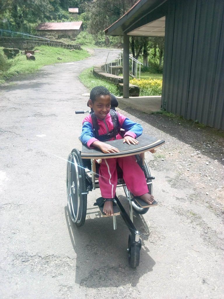 Child smiling in their wheelchair.