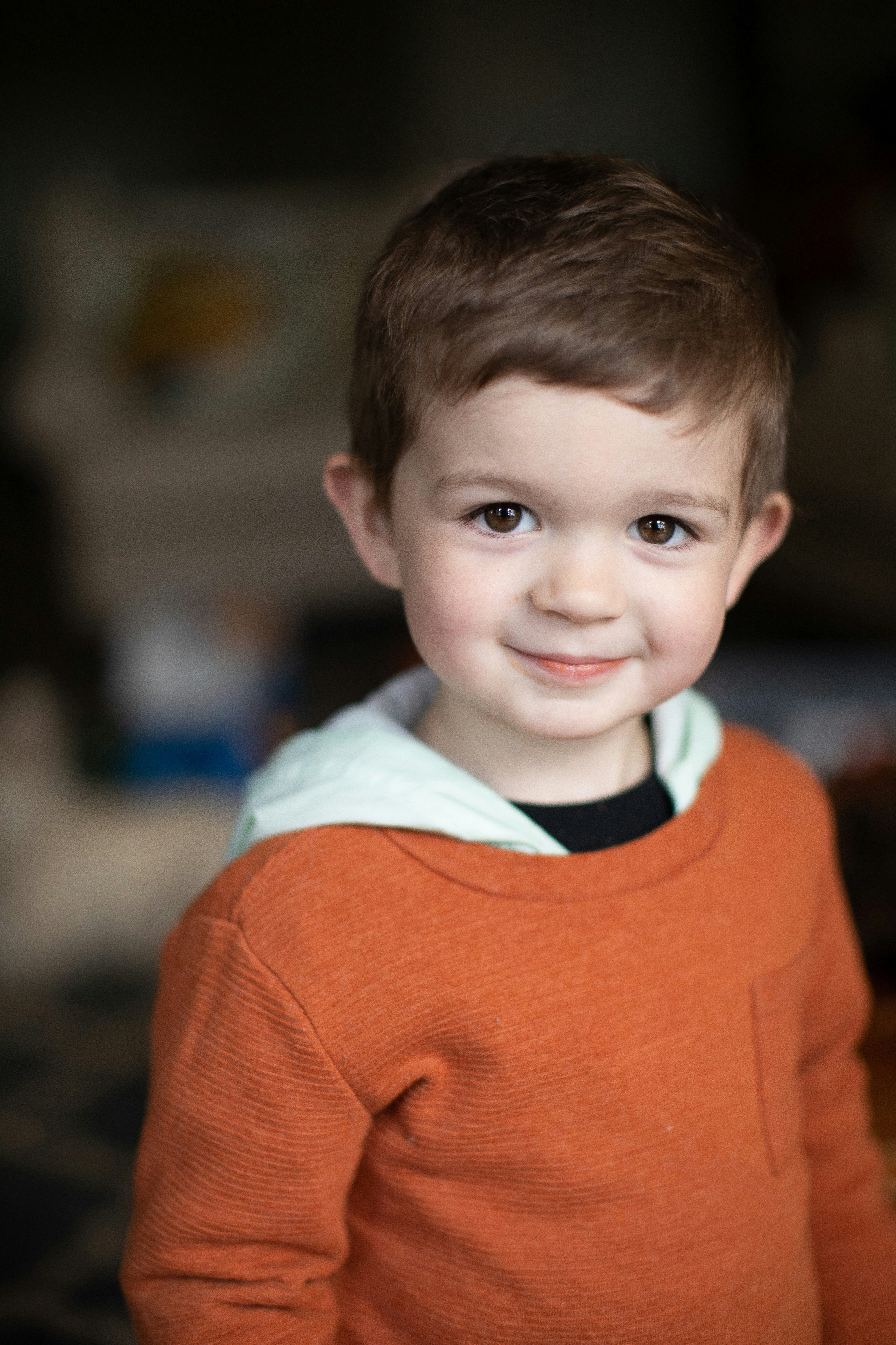 young boy in an orange jacket