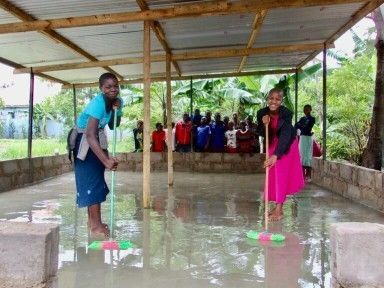 Women washing a cement floor.