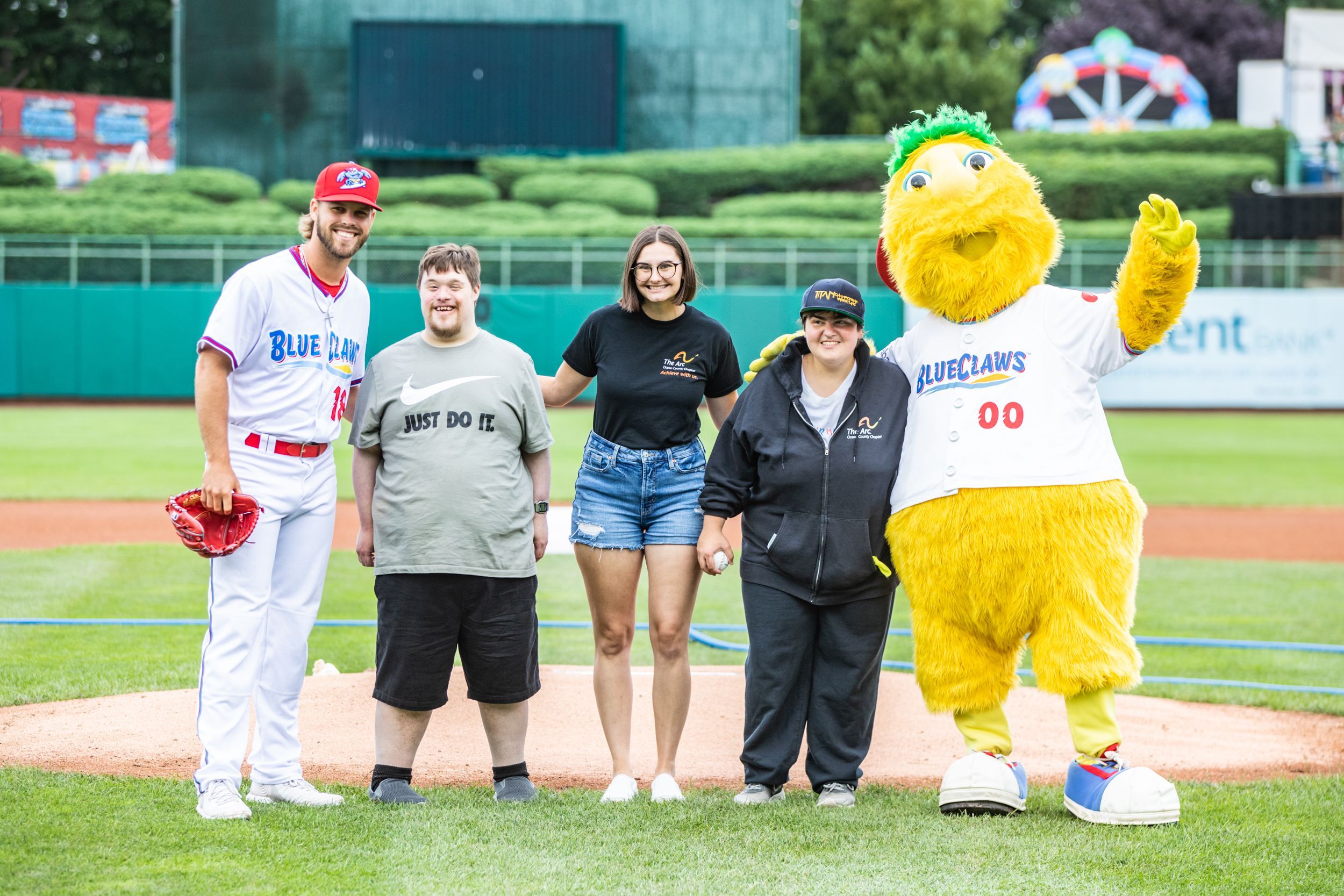 Photo of 2 men, 2 women and Buster the mascot on a baseball field