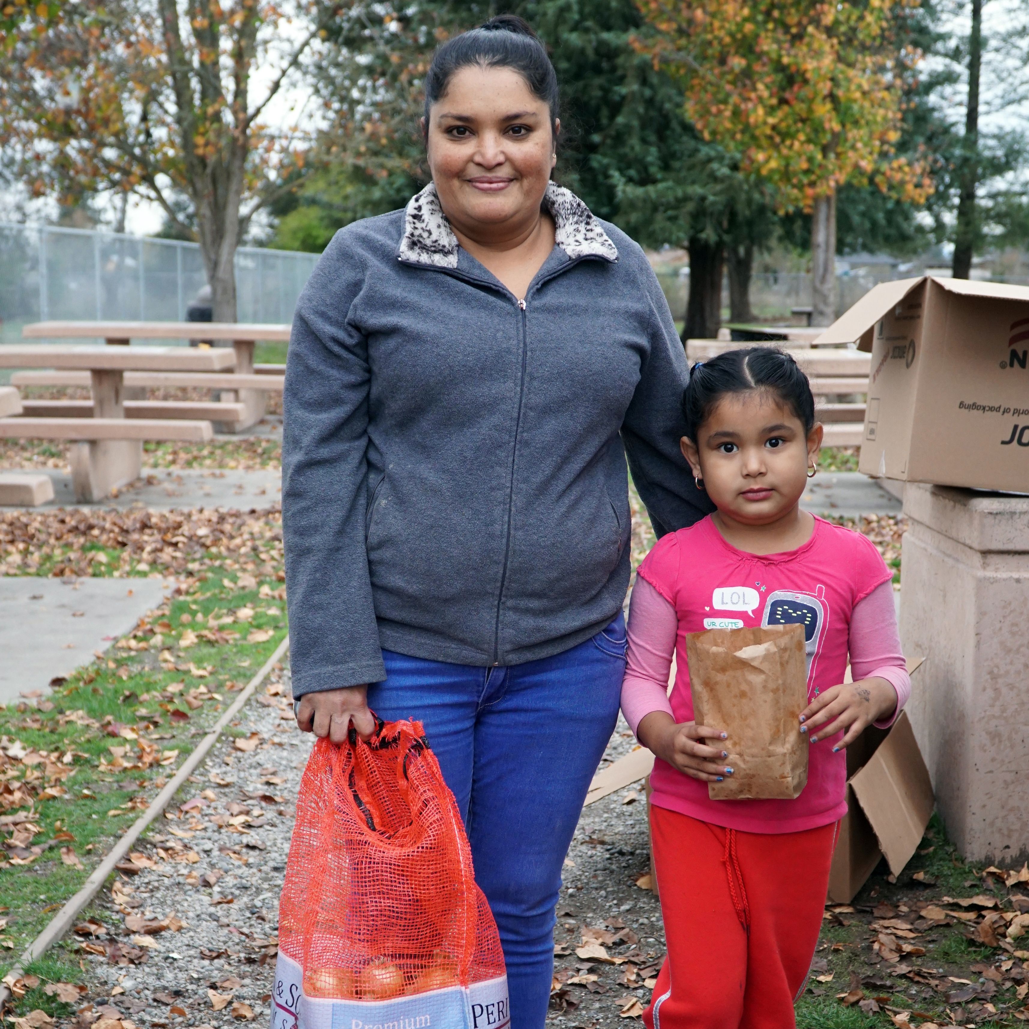 Mother and daughter with food from the food bank