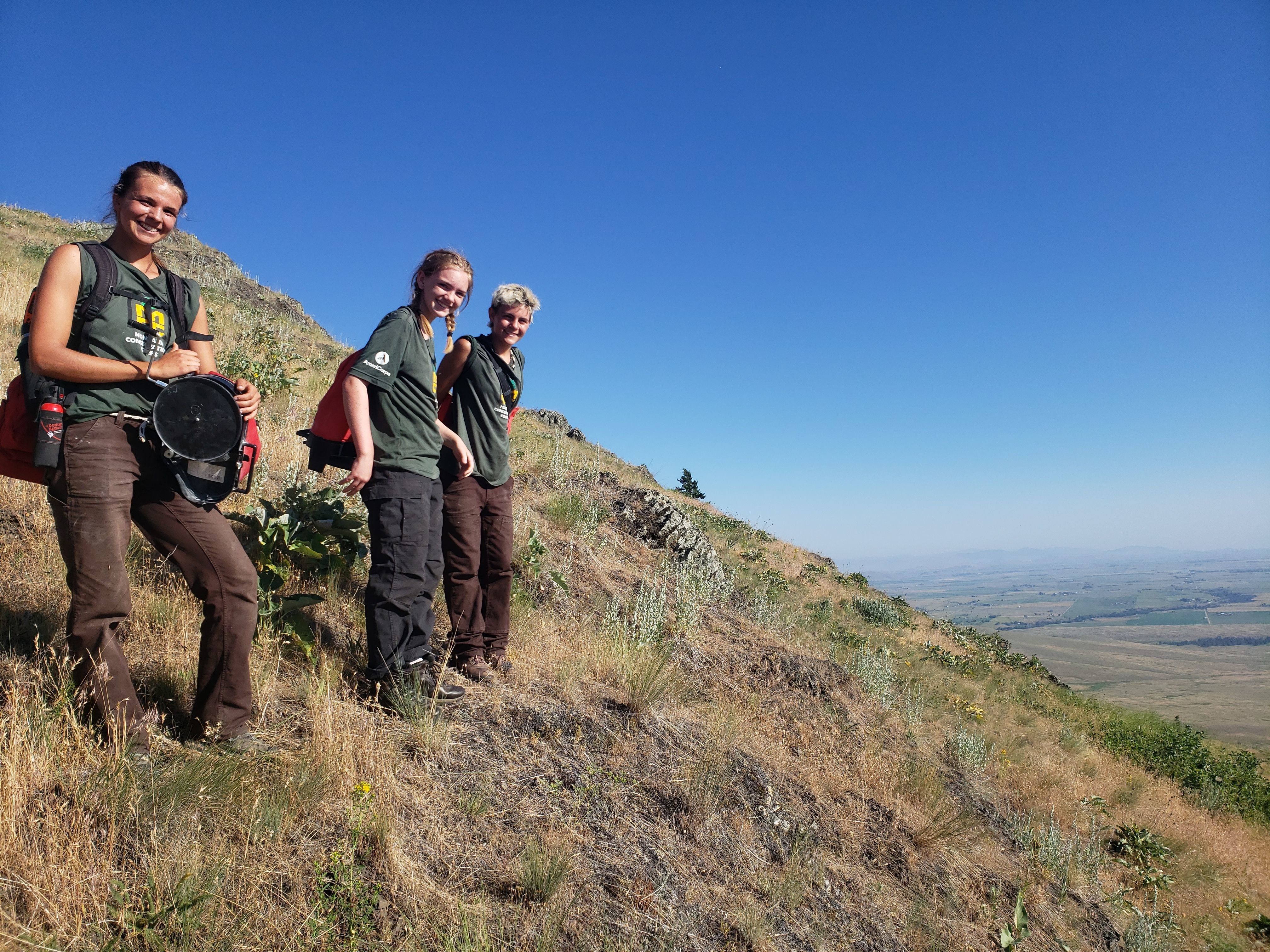 Crew leader Nicole stands with two youth crew members on the Bison Range