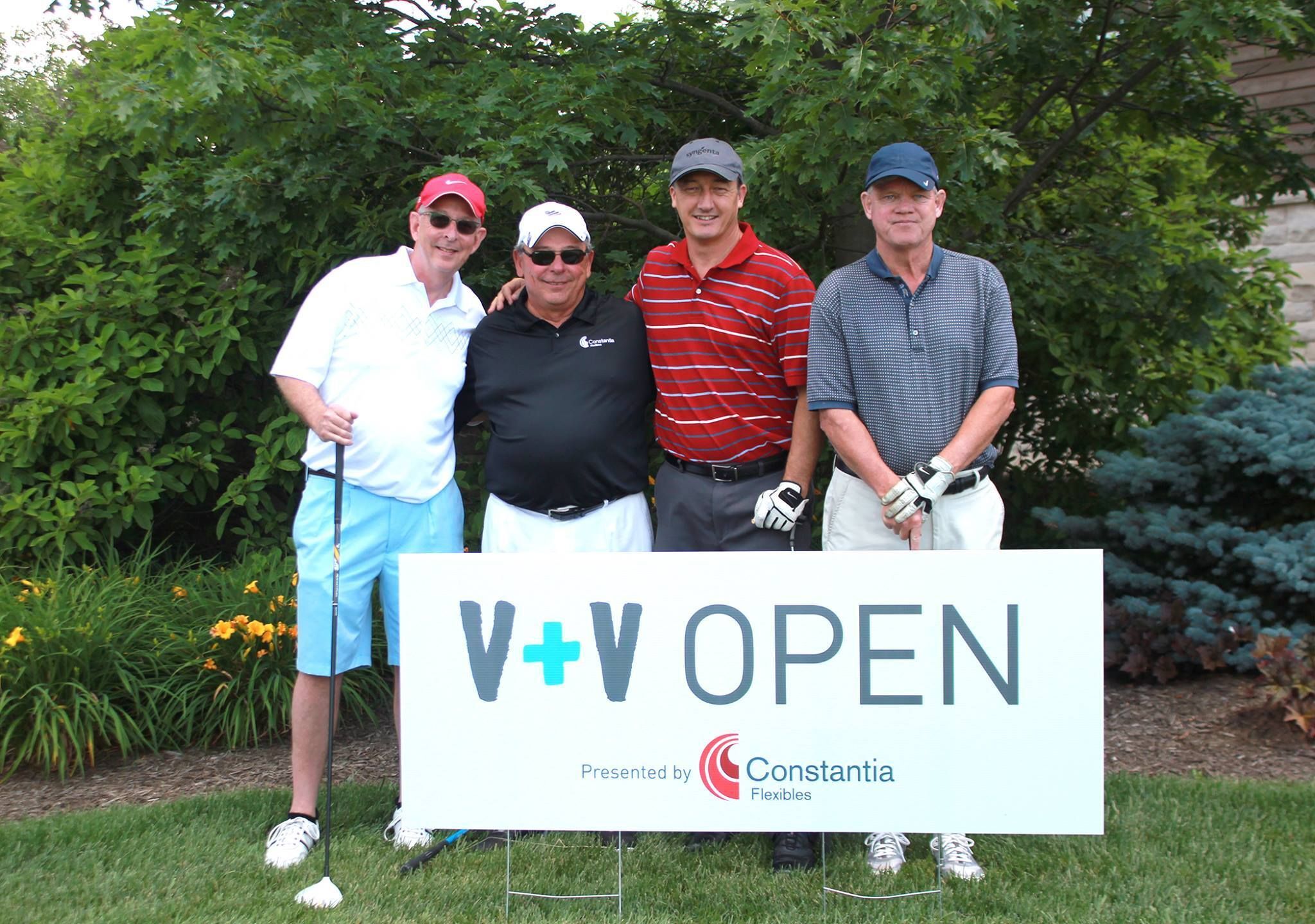 Group of Golfers posing for picture at the Visionary + Voices Golf Outing Fundraiser behind an event sign.
