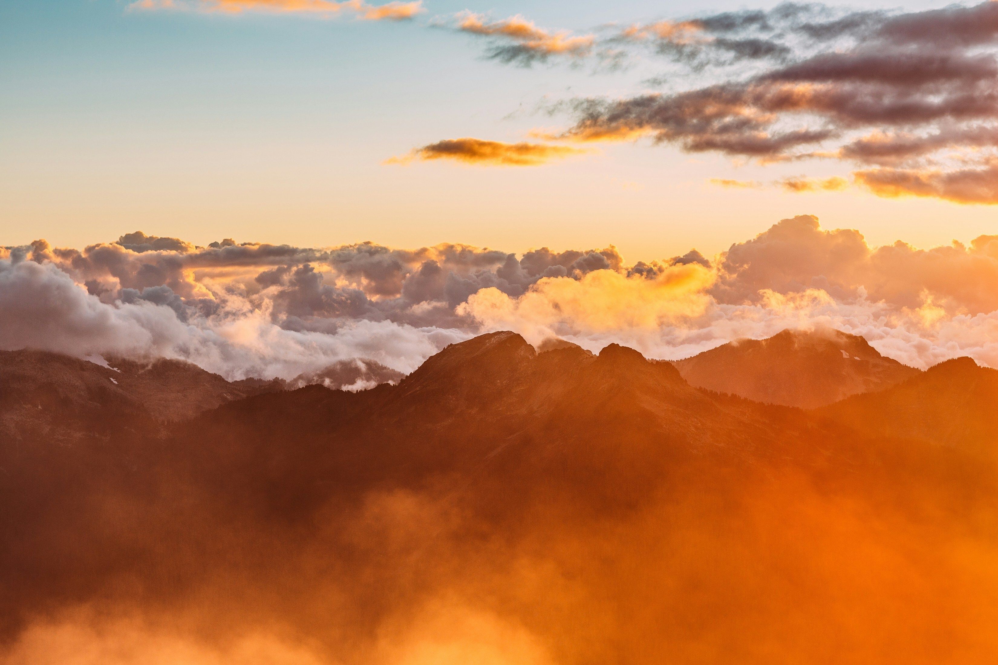 Mountaintops with mist and clouds at sunset