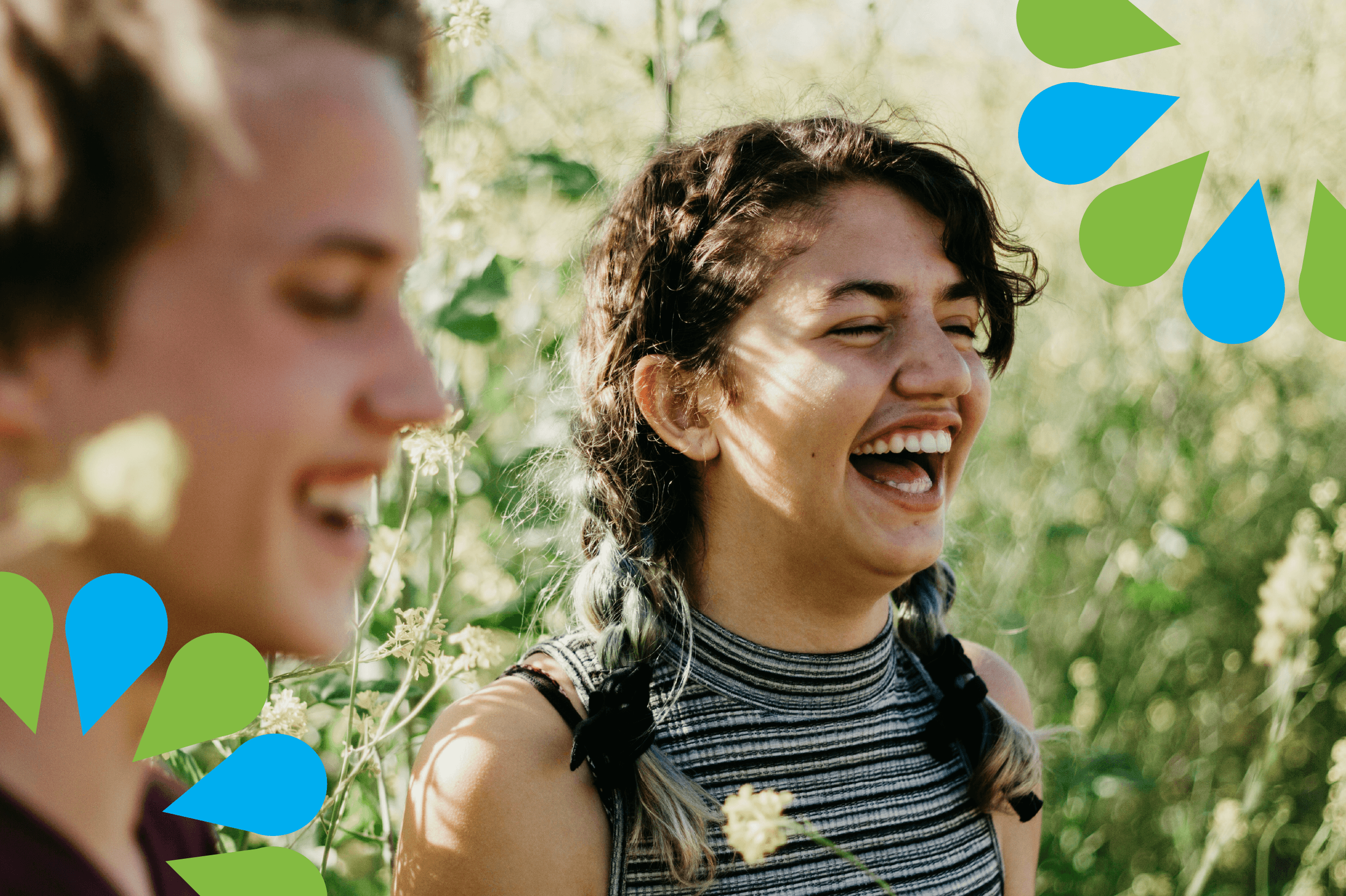Two teenagers in a field laughing