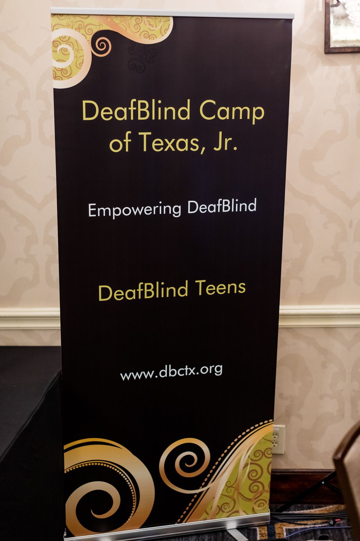 A stand up banner for DeafBlind Camp of Texas, Jr. Empowering DeafBlind. The website listed is www.dbctx.org