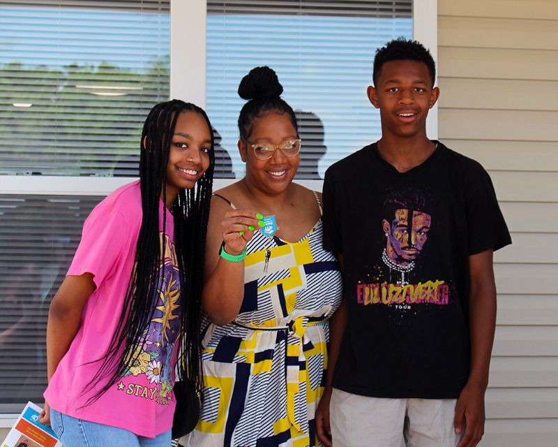 Tiffany and her children celebrate while holding the keys to their new Habitat home.