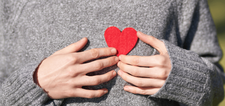 one hand giving another a heart