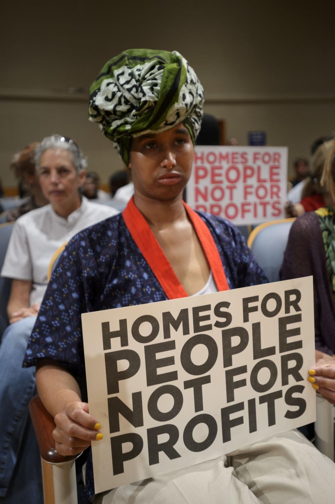 New Orleans Renters Rights Assembly members and tenant holding signs condemning HUD regarding housing issues.