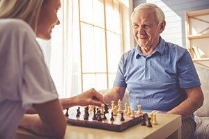 Elderly man and woman playing chess.