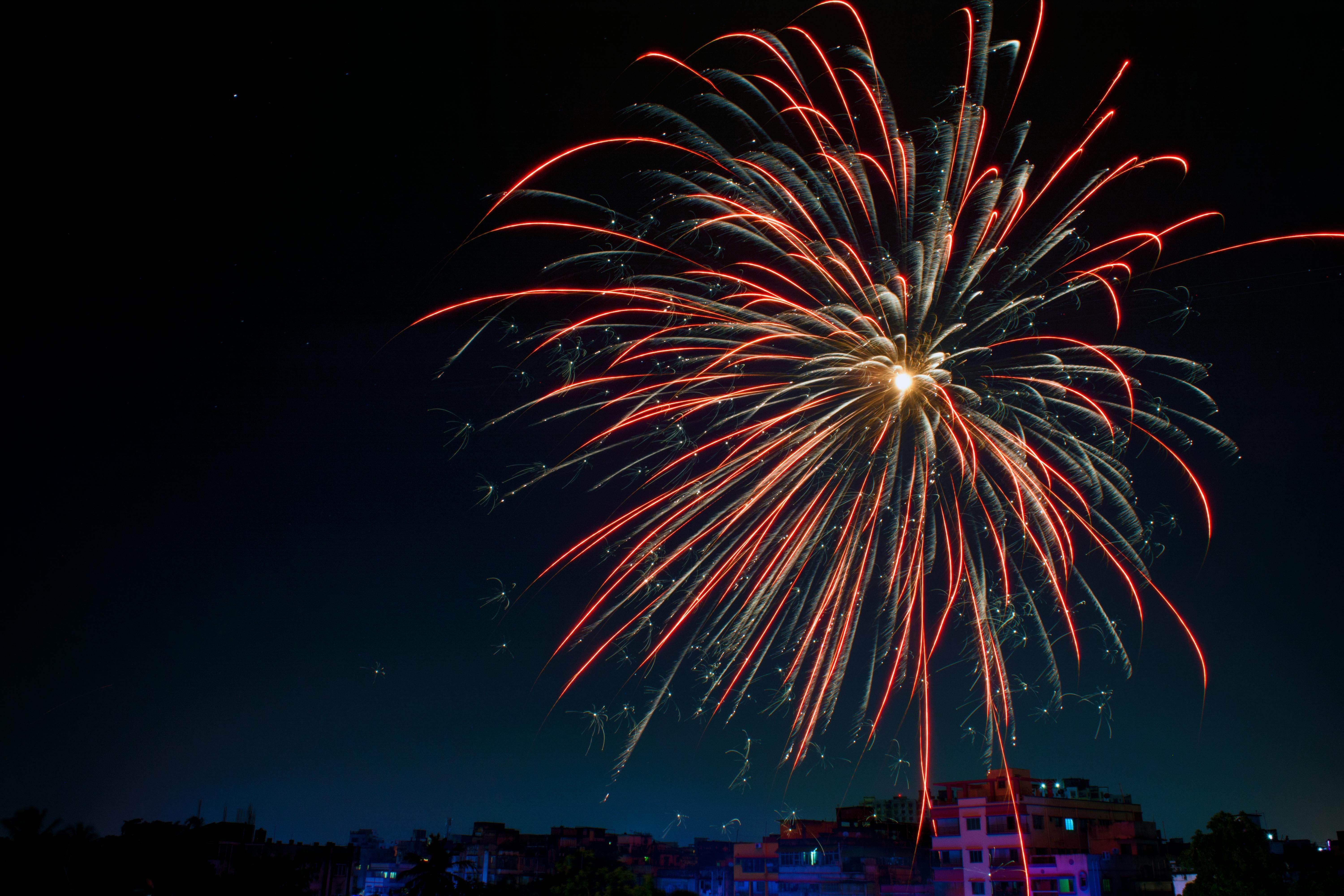 Colored fireworks are in front of a dark night sky 