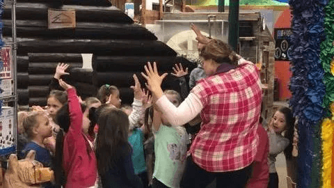 Children cheering with a chaperone.