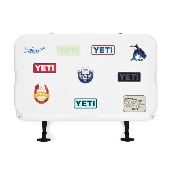 White YETI cooler lid decorated with custom die cut stickers in varied logo styles, showing brand personalization on outdoor gear.