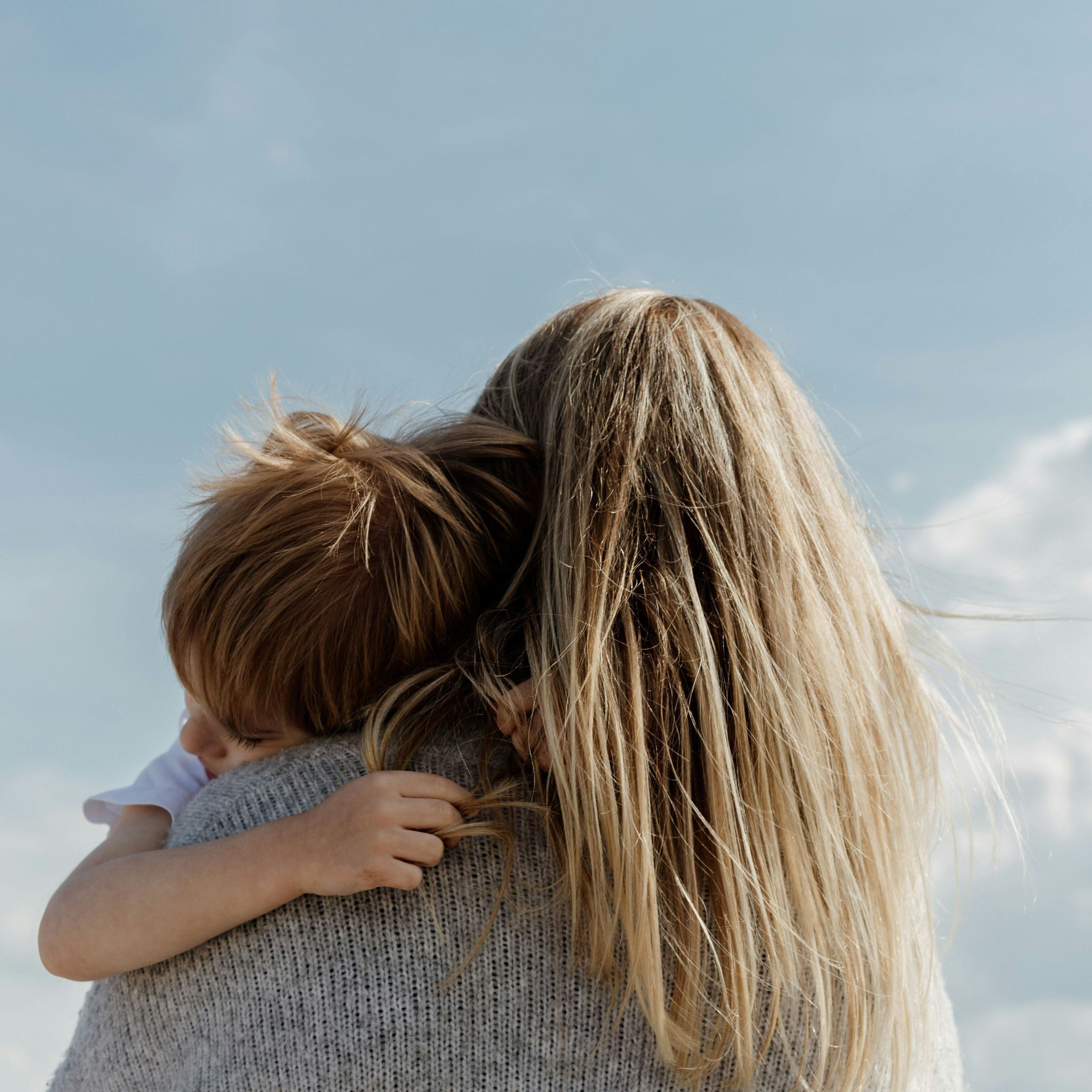 Mother holding child walks away from the camera