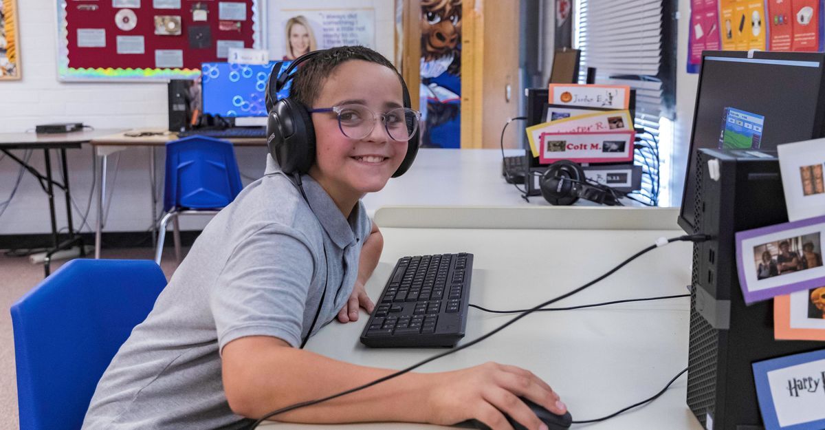 Student smiling at a computer station