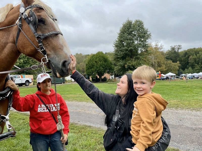 A mother and her young boy make friends with a Belgian horse at Snipes Farm Fall Festival