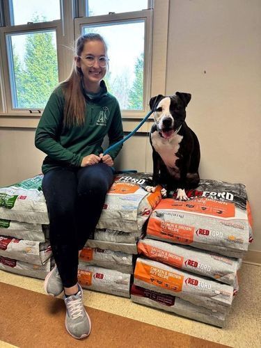 Woman and dog sitting on piles of donated food