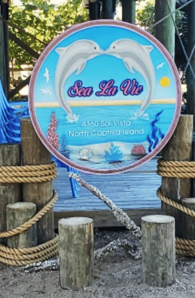 M4844 - Two Back-Mounted  8" Diameter Round Cedar Nautical-style  Posts Supporting  the Sign for the "Sea La Vie" Coastal Vacation Home   Sign . with Four Shorter Posts and Ropes  