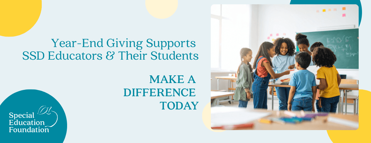 group of kids standing around a desk in a classroom