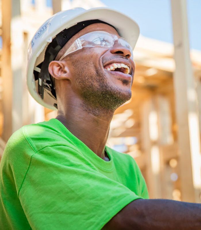 Man in construction attire smiling.