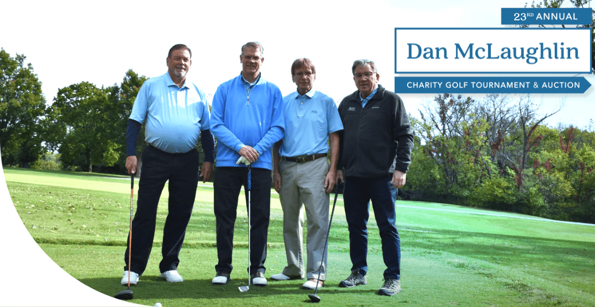 4 adult men standing together on a golf course